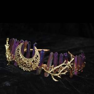 Detailed macro of golden branch metalwork with purple crystal quartz and crescent moon charm