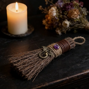 Macro detail of handmade crystal witch broom with dragon pendant and amethyst stone