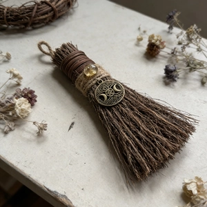 Macro detail of witch broom with citrine crystal and pentagram charm for Christmas decor