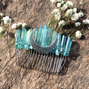 Macro detail of turquoise raw crystals and silver crescent moon on a 20-tooth hair comb