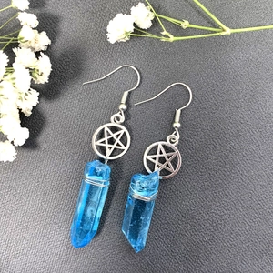Macro shot of celestial star crystal earring with blue natural stone on grey surface