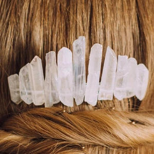Detailed view of raw clear quartz crystals on a silver comb styled in braided brown hair