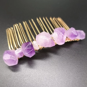 Detail of handmade gold wire-wrapped raw purple amethyst crystals on a 20-tooth hair comb
