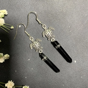 Detail of sea turtle crystal earrings with black hexagonal stone and hook wire