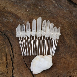 Macro detail of raw white crystal pillars hand-wired to a silver comb for wicca hair styling