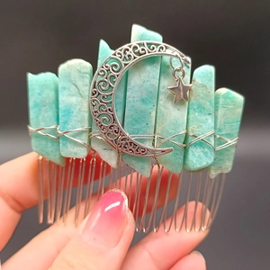 Close-up of bohemian raw turquoise stone hair comb with silver moon and star charms