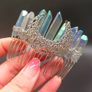 Detail of metal moon hair comb with iridescent crystals and intricate hollow wire pattern