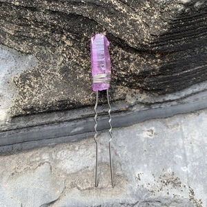 Détail de l'épingle à cheveux avec cristal violet et fil argenté sur surface rocheuse