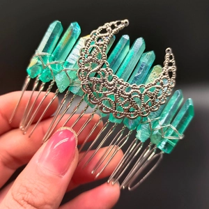Macro shot of green crystal hair comb with intricate silver crescent moon filigree detail