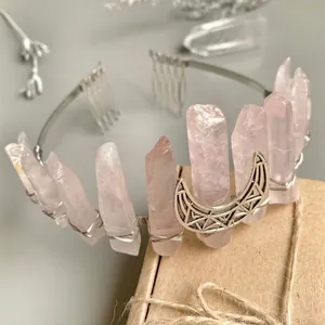 Couronne de cristal rose avec ornement lune en argent sur fond gris minimaliste
