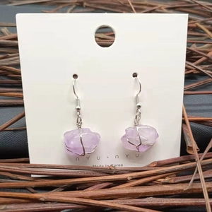 Macro detail of natural purple amethyst drop earrings with handmade silver wire wrapping