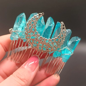 Detail view of light blue crystal clusters and crescent moon filigree on hair comb