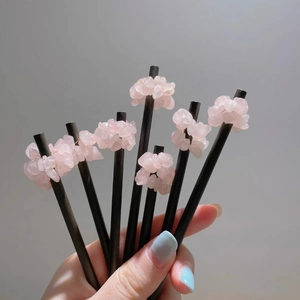 Detail view of six handmade wooden hair pins with natural rose quartz stone clusters