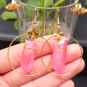 Close-up of pink hexagonal crystal hoop earrings with gold wire wrap in boho style