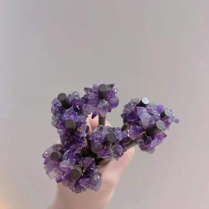 Close-up of handmade amethyst stone chips wrapped on dark wood hair stick pins