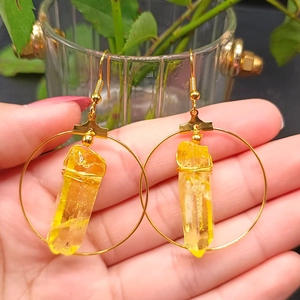 Detail of yellow crystal column earrings with gold wire wrap and round hoop charm