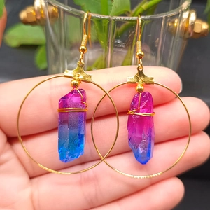 Detail of handmade gold hoop earrings featuring gradient purple crystal druzy pendants