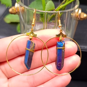 Detail of gold hoop earrings featuring gradient crystal pendants with wire wrapping