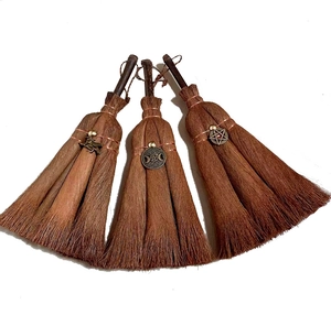Detail of mini Wiccan broom pendants with witchy metal charms and crystal accents