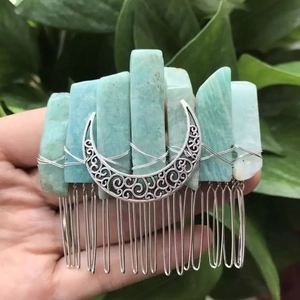 Detail of bohemian hair comb featuring raw green crystals and a silver crescent moon charm