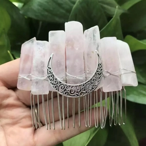 Macro detail of handmade pink crystal hair comb with vintage silver crescent moon ornament