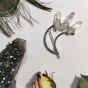 Detail view of handmade crescent moon hair clip with three raw white crystal points