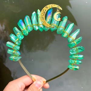 Detail of handmade green crystal crown featuring golden moon and star pendant charms