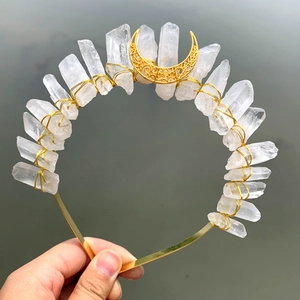 Detailed view of raw quartz crystals and crescent moon on a gold tiara headband