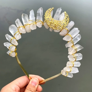 Macro detail of raw white crystal crown with gold wire wrapping and crescent moon piece