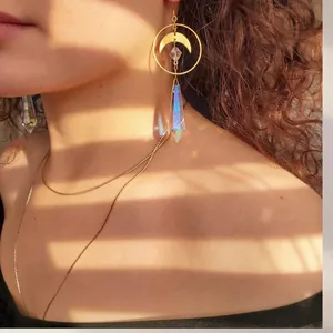 Bohemian gold crescent moon earrings with iridescent crystal pendant on female model