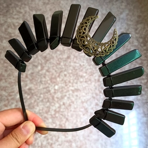 Détail d'une couronne gothique en cristaux noirs avec breloque de lune en bronze antique