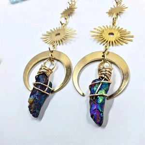 Macro detail of sun and moon crystal earrings with iridescent bohemian mineral stones