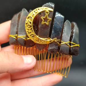 Close-up of handmade gothic hair comb with natural raw crystal points and golden moon star