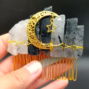 Detail of handmade crystal hair comb featuring gold wire wrapped moon and star accents