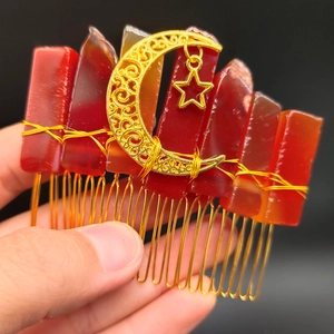 Macro detail of handmade hair comb with moon star charm and red crystal stones