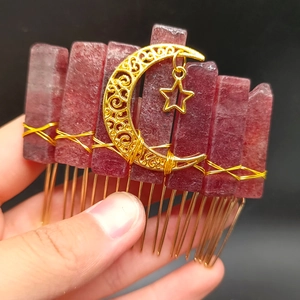 Detailed view of bohemian moon and star hair comb with raw pink crystal stones