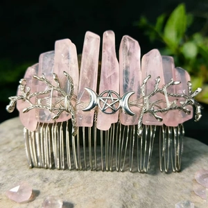 Detail of rose quartz hair comb with silver branches and mystical moon symbols