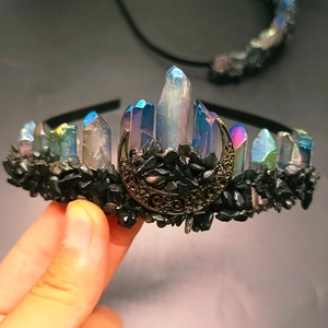Macro di una fascia per capelli artigianale con cristalli iridescenti e luna di bronzo