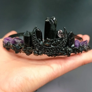 Detailed close-up of gothic crown featuring black crystal points and a metal moon charm