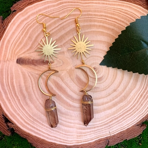 Détail des boucles d'oreilles bohèmes soleil et lune avec cristal sur bois naturel