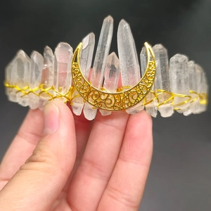 Detail of handmade white crystal moon crown with gold wire wrap on black background