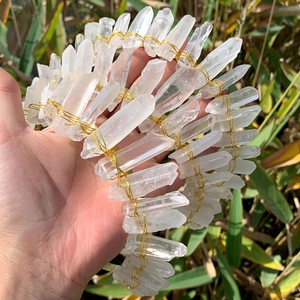 Detail of natural clear quartz crystals hand-wrapped with golden wire on a headband