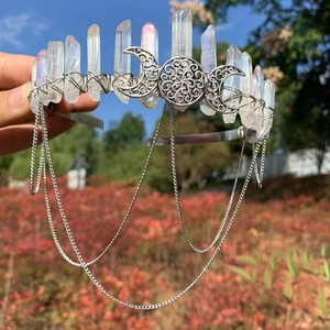 Close-up of handmade white crystal crown with moon totem and hanging metal chain tassels