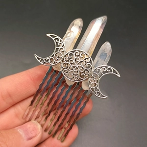 Macro detail of the triple goddess moon charm and natural crystal pillars on the hair comb