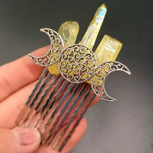Close-up of silver crescent moon hair comb featuring raw yellow crystal clusters
