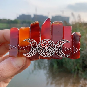 Detail of bohemian triple moon hair clip with red raw stones and wire-wrapped finish