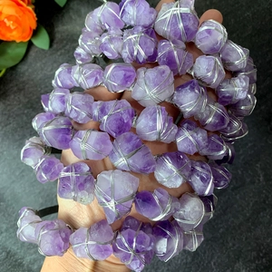 Dettaglio di pietre grezze di ametista avvolte in filo d'argento su una corona bohémien
