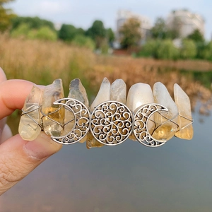 Detail of bohemian crystal moon hair clip with raw citrine stones and silver wire wrap