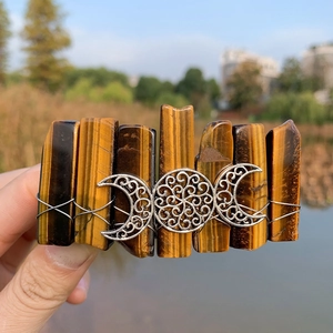 Detailed view of bohemian tiger eye stone hair clip with silver triple moon metal decor