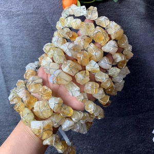 Dettaglio di pietre di citrino naturale avvolte a mano con filo d'argento sulla corona